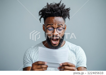 Young man gasps with excitement upon reading acceptance letter to dream university 122405610