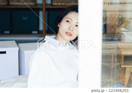 室内から外を眺めめる女性 122406203