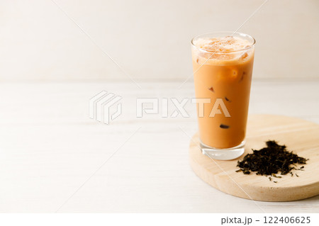 Iced Thai milk tea in a glass on wooden table. 122406625