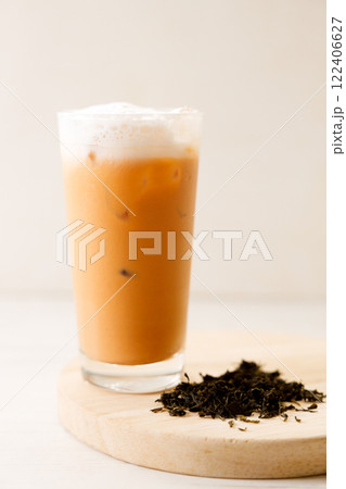 Iced Thai milk tea in a glass on wooden table. 122406627