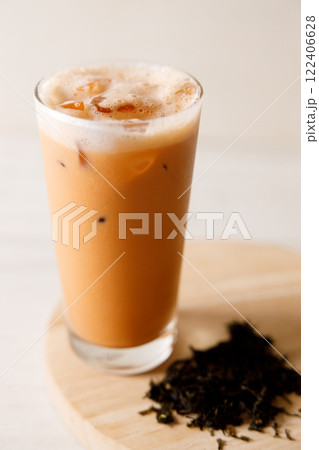 Iced Thai milk tea in a glass on wooden table. 122406628