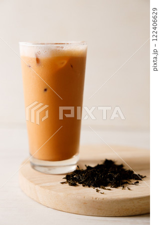Iced Thai milk tea in a glass on wooden table. 122406629