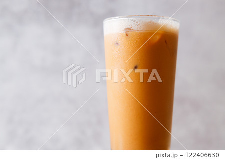 Iced Thai milk tea in a glass on wooden table. 122406630