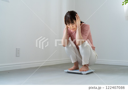 体重計に乗ってがっかりする女性 122407086
