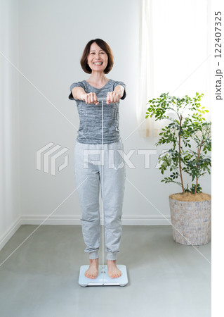 体重体組成計で測定する女性 体重体組成計で測定する女性 122407325