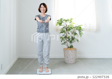 体重体組成計で測定する女性 体重体組成計で測定する女性 122407326