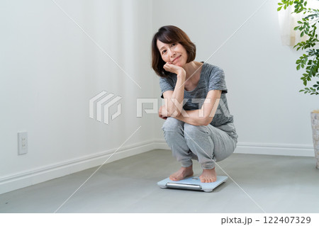 体重計に乗ってがっかりする女性 122407329