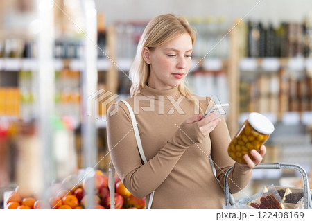 Young woman scanning qr code of olives Young woman scanning qr code of olives 122408169