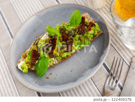 Sandwich with cheese and guacamole, dried tomatoes and seeds 122408376
