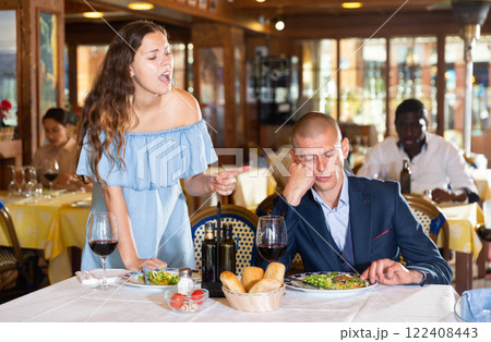 Unhappy couple quarreling during dinner at restaurant 122408443