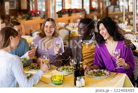 Adult men and women having friendly meeting at dinner in restaurant Adult men and women having friendly meeting at dinner in restaurant 122408485