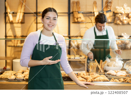 Smiling young waitress, bakery saleswoman in apron looking at the camera during working day in cafe Smiling young waitress, bakery saleswoman in apron looking at the camera during working day in cafe 122408507