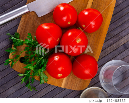 Fresh organic tomatoes on wooden kitchen table 122408585