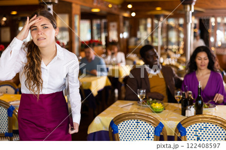 Portrait of tired upset waitress in the hall of restaurant Portrait of tired upset waitress in the hall of restaurant 122408597