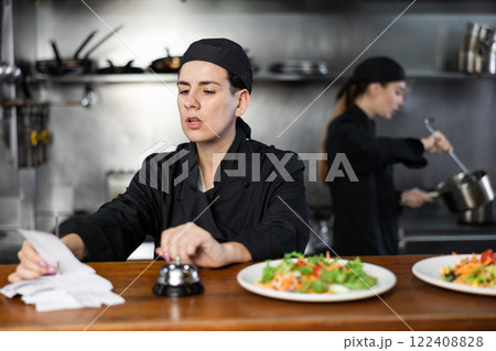 Chef checking orders and giving out meal Chef checking orders and giving out meal 122408828
