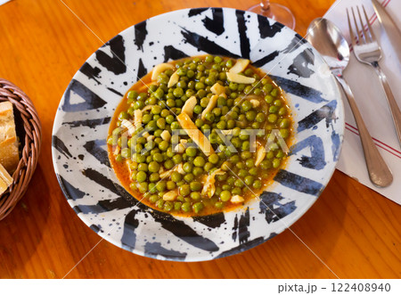 Green peas stewed with pieces of squid in appetizing gravy 122408940