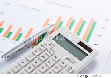 会社の業績グラフと電卓 122409092