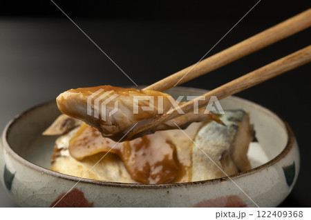 皿に盛り付けた鯖の味噌煮を箸で持ち上げる 122409368