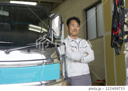 トラックの横に立つ作業服を着た男性のポートレート トラックの横に立つ作業服を着た男性のポートレート 122409733