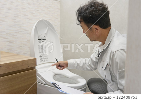 トイレの故障をチェックする修理業者の男性 トイレの故障をチェックする修理業者の男性 122409753