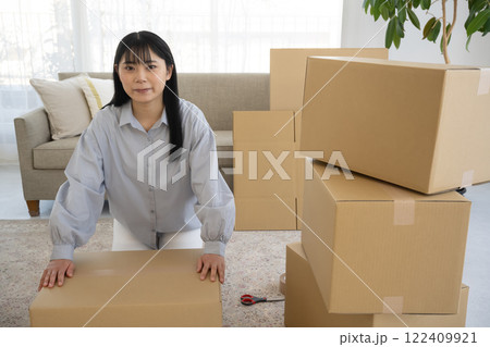 若い女性の引っ越し段ボール荷造りシーン 若い女性の引っ越し段ボール荷造りシーン 122409921