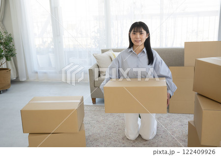 若い女性の引っ越し段ボール荷造りシーン 若い女性の引っ越し段ボール荷造りシーン 122409926
