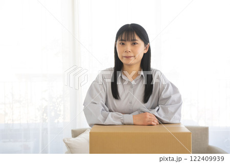 段ボール箱に肘をつく女性 段ボール箱に肘をつく女性 122409939