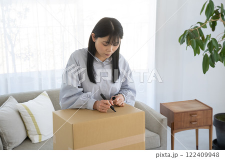 段ボール箱にマジックで書く女性 段ボール箱にマジックで書く女性 122409948