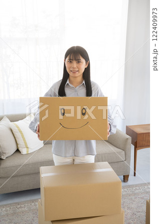 段ボール箱に笑顔のイラストを書いた箱を持つ女性 段ボール箱に笑顔のイラストを書いた箱を持つ女性 122409973