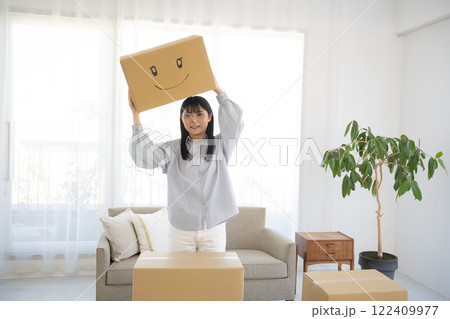 段ボール箱に笑顔のイラストを書いた箱を持つ女性 段ボール箱に笑顔のイラストを書いた箱を持つ女性 122409977
