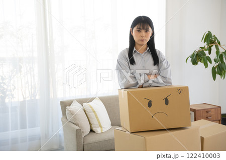 段ボール箱に顔の絵を描いて肘をつく女性 段ボール箱に顔の絵を描いて肘をつく女性 122410003