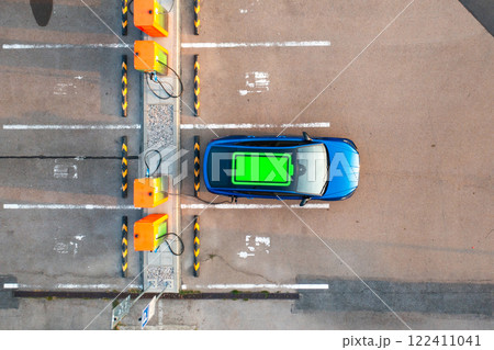Green battery power status indicator is visible on the roof of an electric vehicle at a public charging point. Green battery power status indicator is visible on the roof of an electric vehicle at a public charging point. 122411041