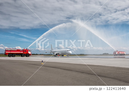 Water arch for first visit white passenger airliner at the airport Water arch for first visit white passenger airliner at the airport 122411640