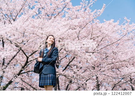 桜並木の下を歩く女子高生 122412007