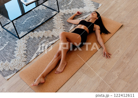 Woman lying on the floor resting after a workout at home 122412611