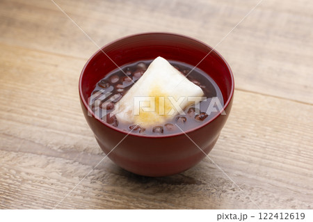 木目のテーブルに香ばしく焼かれたお餅入りのぜんざい 木目のテーブルに香ばしく焼かれたお餅入りのぜんざい 122412619