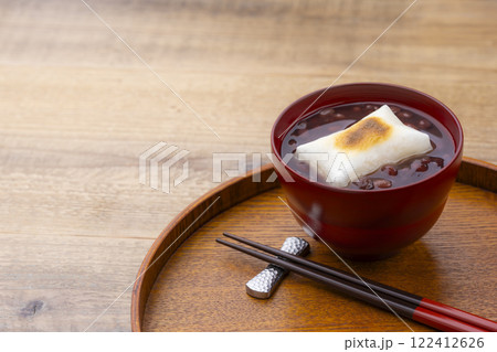 木目のテーブルに香ばしく焼かれたお餅入りのぜんざい 122412626