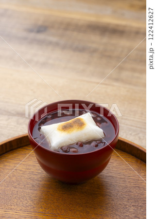 木目のテーブルに香ばしく焼かれたお餅入りのぜんざい 122412627