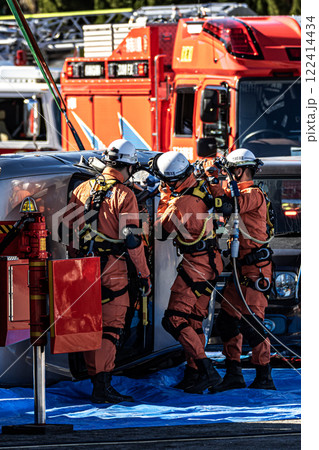 出初式の消防訓練で事故で横転した自動車のルーフを油圧カッターで切断する救助訓練を行うレスキュー隊員 122414434