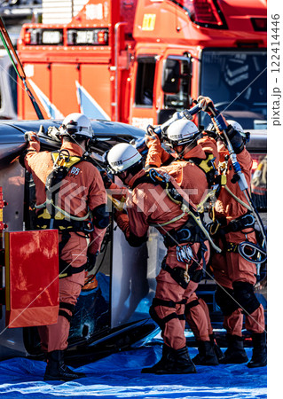 出初式の消防訓練で事故で横転した自動車のルーフを油圧カッターで切断する救助訓練を行うレスキュー隊員 122414446