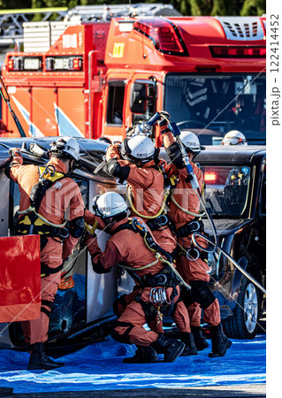 出初式の消防訓練で事故で横転した自動車のルーフを油圧カッターで切断する救助訓練を行うレスキュー隊員 122414452