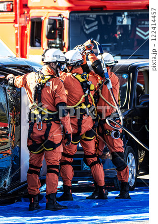 出初式の消防訓練で事故で横転した自動車のルーフを油圧カッターで切断する救助訓練を行うレスキュー隊員 出初式の消防訓練で事故で横転した自動車のルーフを油圧カッターで切断する救助訓練を行うレスキュー隊員 122414457