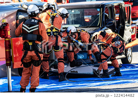 出初式の消防訓練で事故で横転した自動車のルーフを油圧カッターで切断する救助訓練を行うレスキュー隊員 122414482
