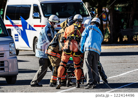 出初式の消防訓練で消防隊員により救助された怪我人をストレッチャーで搬送する救急隊員 122414496