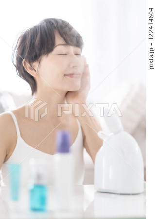 美顔スチーマーでスチームクレンジングするミドル女性 122414604