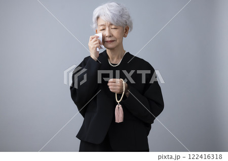 喪服　スマホで電話をかけているシニア女性 122416318