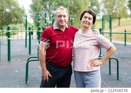 Elderly man and woman posing in open-air sports bars complex Elderly man and woman posing in open-air sports bars complex 122416576