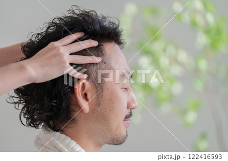 ヘッドマッサージの施術を受ける男性 122416593