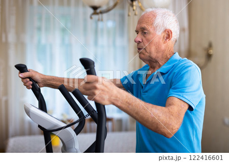 Male is working out on elliptical machine for elder healthy concept Male is working out on elliptical machine for elder healthy concept 122416601