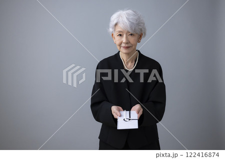 葬儀　香典袋を差し出すシニア女性 122416874